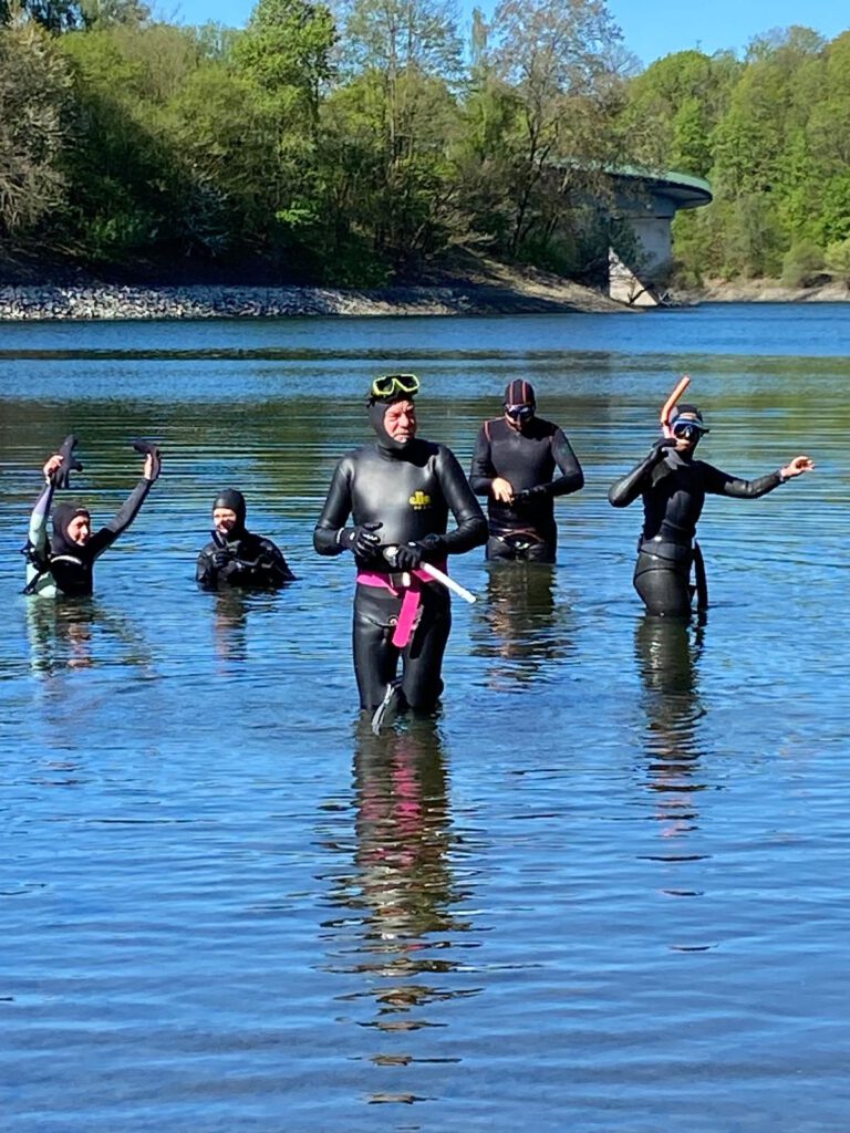 Einstieg in die Wuppertalsperre. Fünf Schwimmer begeben sich in Neoprenanzügen ins Wasser.