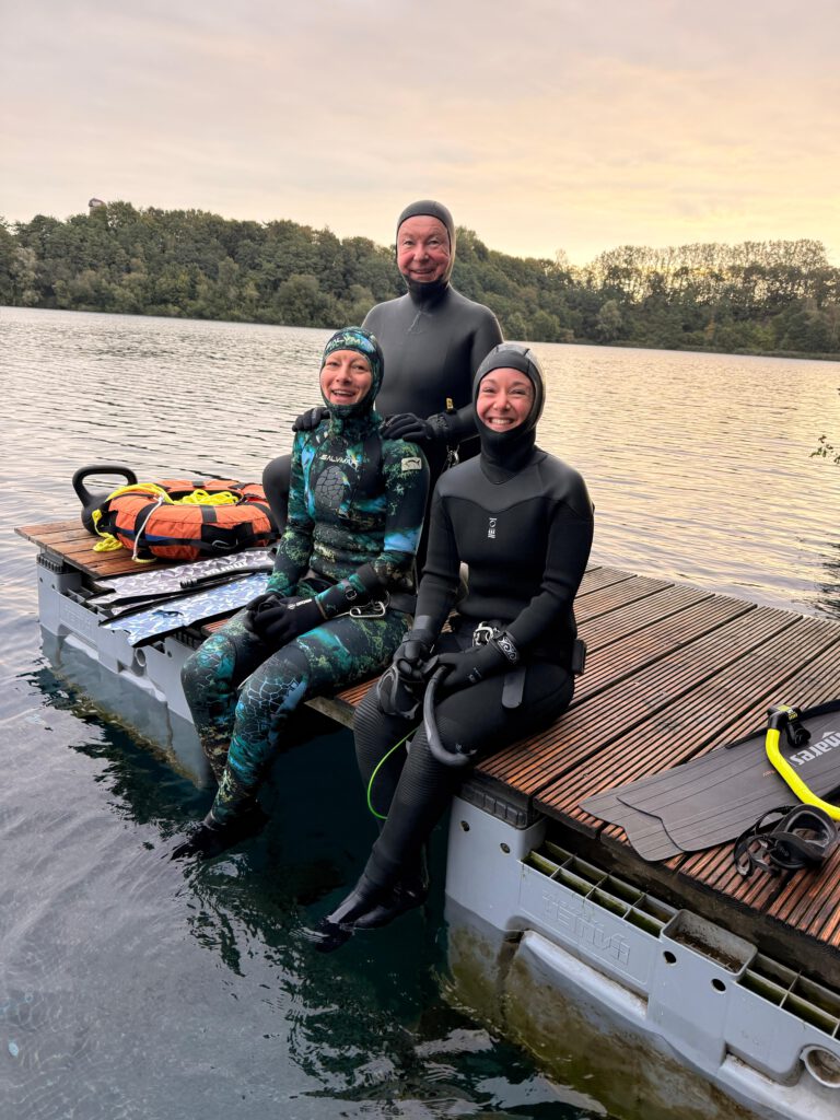 Drei Taucher auf dem Weg ins Wasser
