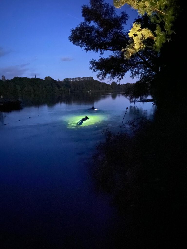 Zwei Taucher beim Nachttauchgang im See